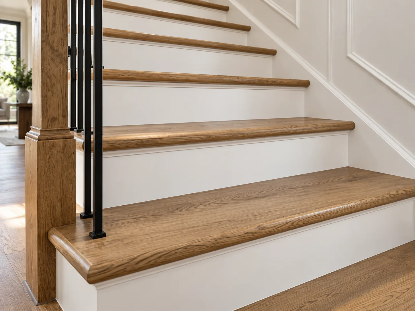 Close view of oak stair treads with white risers and black balusters