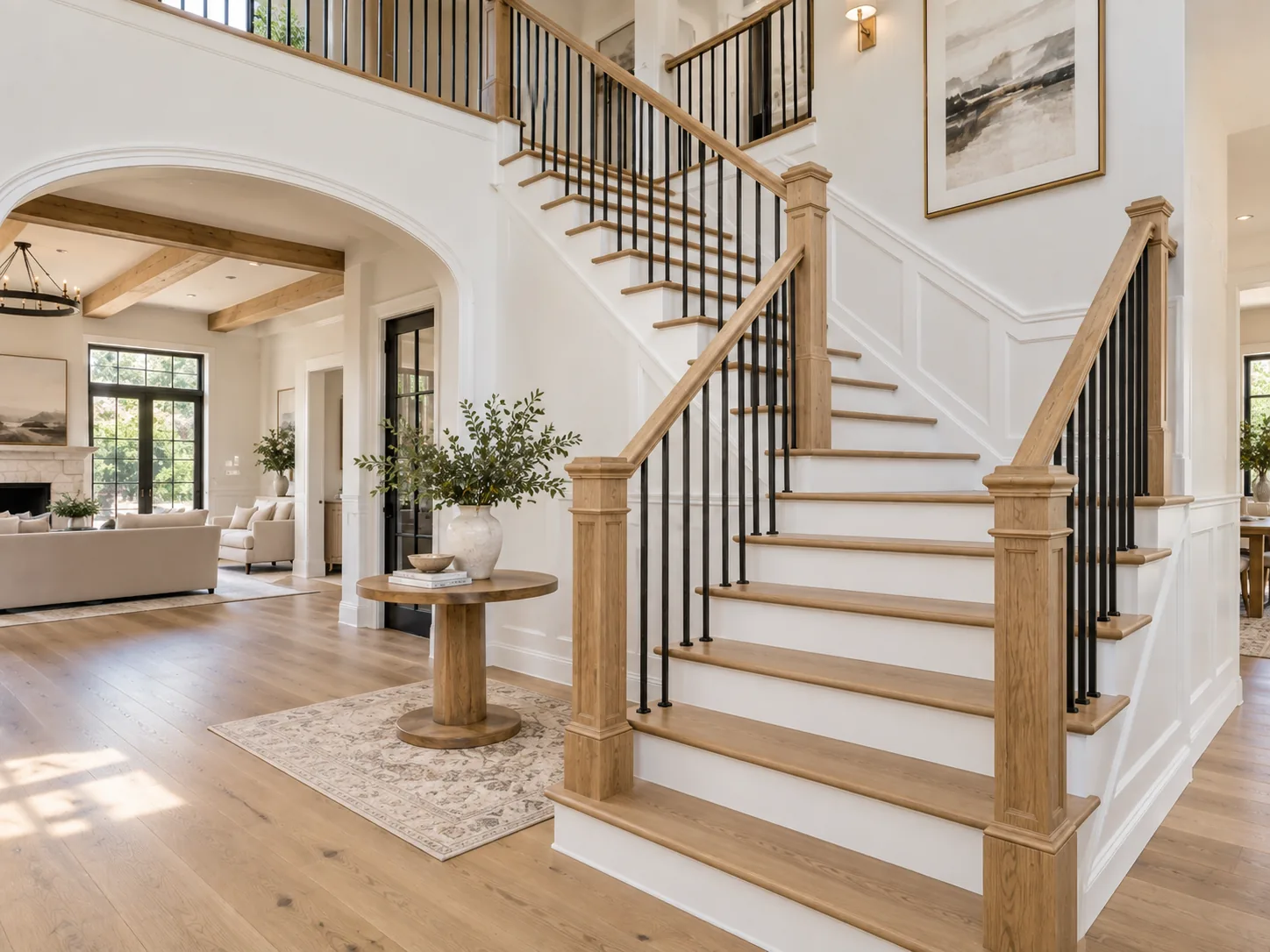 Remodeled wood staircase with black metal balusters and custom newel posts